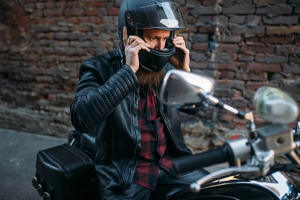 Motorcycle rider wearing helmet for safety.