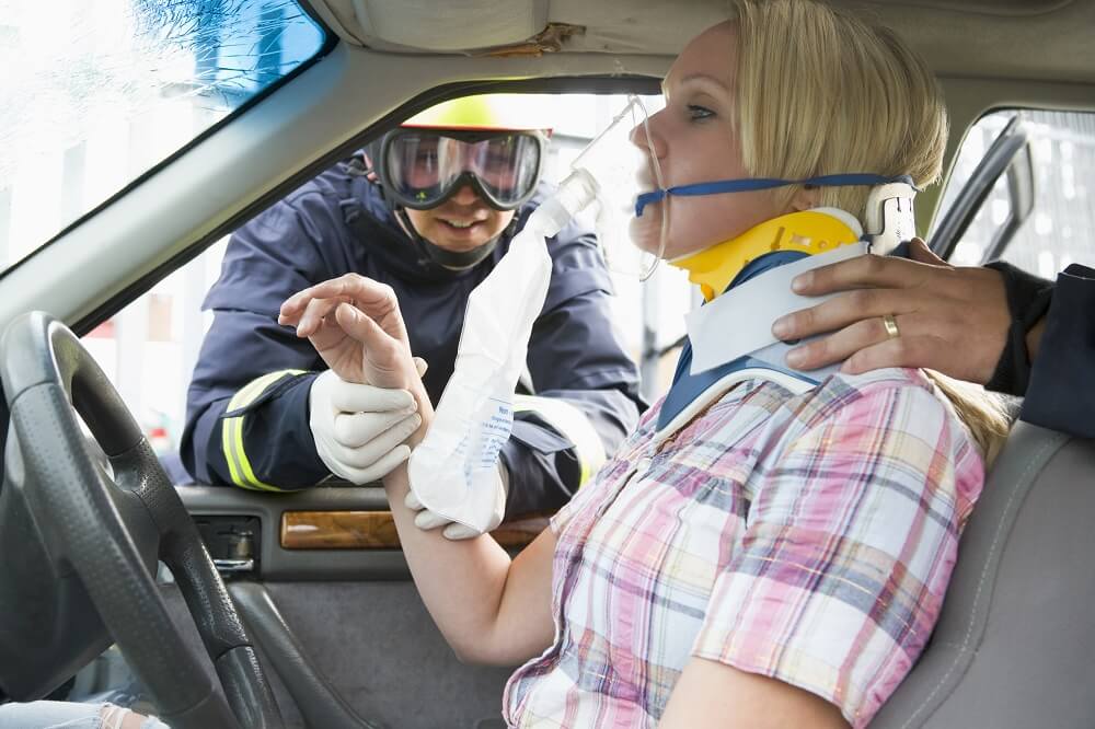 Injured female driver being rescued from car accident.