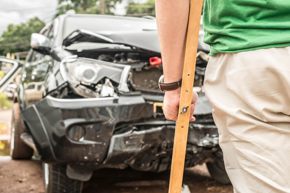 Injured driver from car accident on crutches.