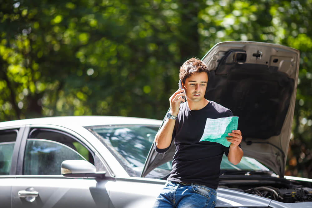 Driver calling insurance to report accident.