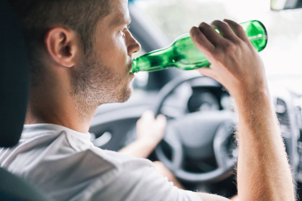 Driver is drinking liquor while driving.