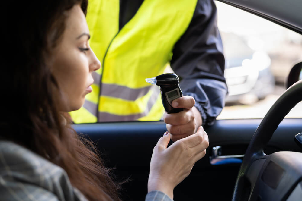 Policeman doing driver alcohol test using breathalyzer