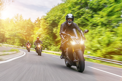 group of motorcycle riders riding on the road