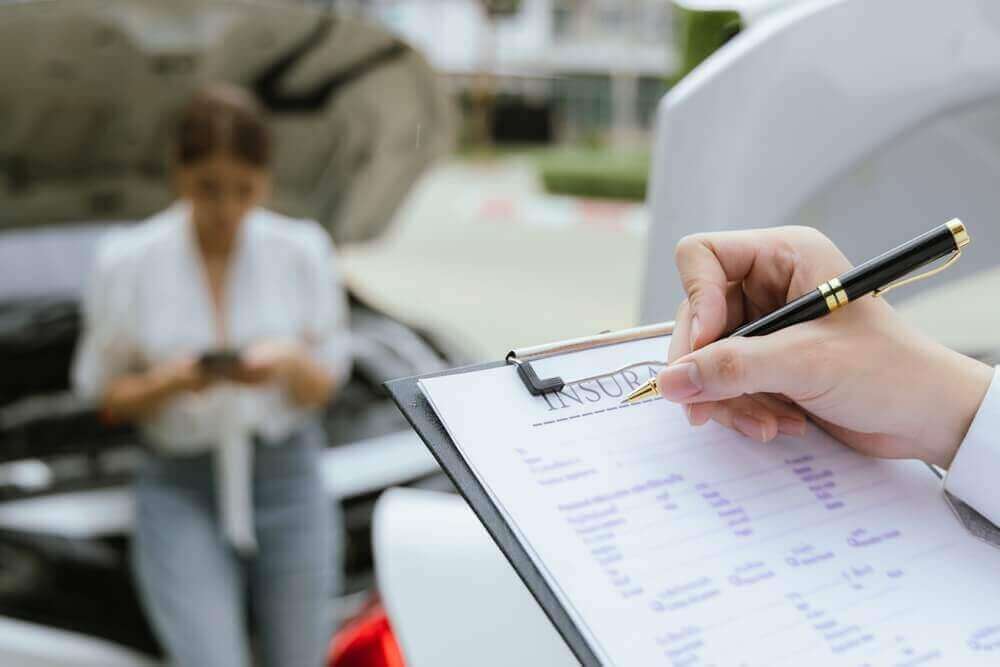 Insurance agent checking damaged car from accident.